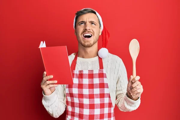 Handsome Caucasian Man Cooking Wearing Baker Apron Christmas Hat Angry — Stock fotografie