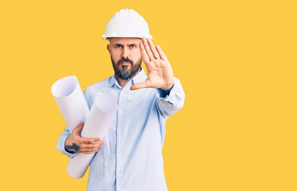 Young Handsome Man Wearing Hardhat Holding Paper Blueprints Open Hand — 스톡 사진