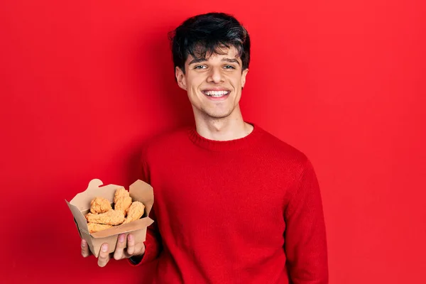 Bonito Hipster Jovem Comendo Asas Frango Olhando Positivo Feliz Sorrindo — Fotografia de Stock