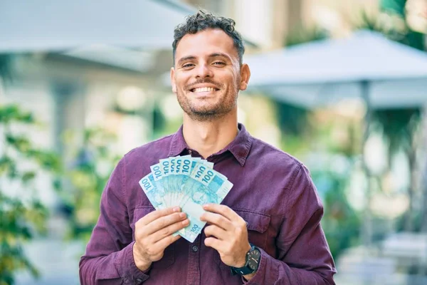 Junger Hispanischer Mann Lächelt Glücklich Und Hält Brasilianische Echte Banknoten — Stockfoto