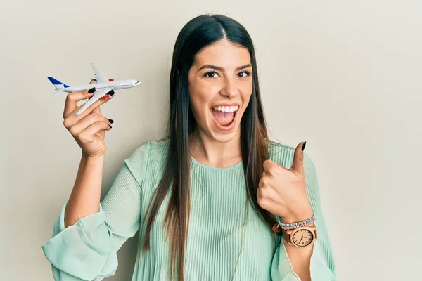 Young Hispanic Woman Holding Airplane Toy Smiling Happy Positive Thumb — Stock fotografie