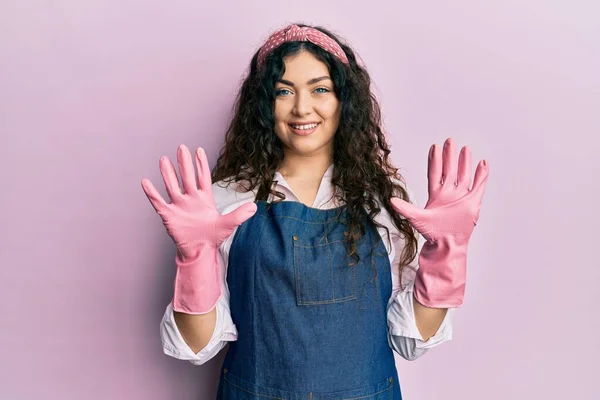 Young Brunette Woman Curly Hair Wearing Cleaner Apron Gloves Showing — Φωτογραφία Αρχείου