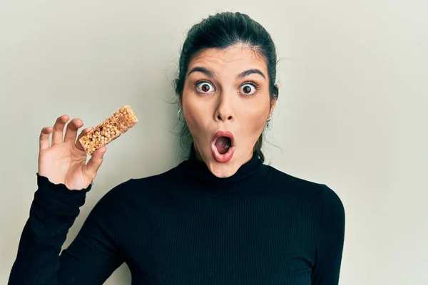 Young Hispanic Woman Eating Protein Bar Healthy Energy Snack Scared — Stock Photo, Image