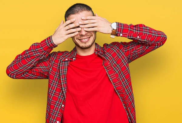 Jovem Hispânico Vestindo Roupas Casuais Cobrindo Olhos Com Mãos Sorridentes — Fotografia de Stock
