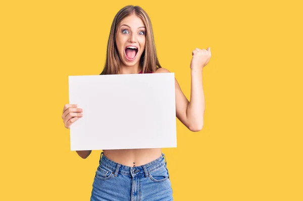 Young Beautiful Blonde Woman Holding Blank Empty Banner Screaming Proud — Stock Photo, Image