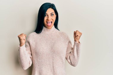 Sıradan bir kazak giyen genç beyaz kadın kollarını kaldırıp, gözlerini açarak başarıyı kutluyor. Kazanan konsept. 