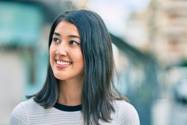 Genç İspanyol kadın gülümseyerek şehirde mutlu mesut yürüyor..