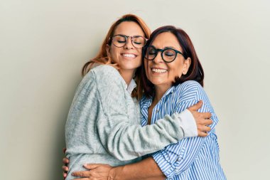 İspanyol anne ve kızı mutlu bir şekilde gülümsüyor ve sarılıyor..