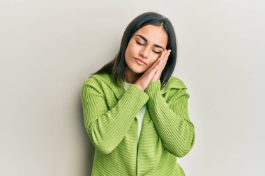 Genç esmer kadın gündelik giysiler giyip uyuyordu. Yorgun düşler görüyordu. Elleriyle poz verirken gözleri kapalıydı.. 