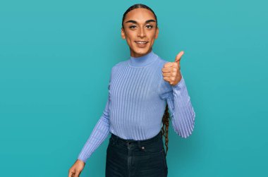 Makyaj yapan İspanyol transseksüel adam ve günlük kıyafetler giyen mutlu ve pozitif gülümseyen, mükemmel ve onay işareti yapan uzun saçlı adam. 