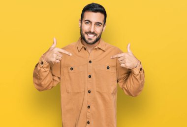 Günlük kıyafetler giyen, kendine güveni olan, kendini gururlu ve mutlu gösteren genç İspanyol bir adam.. 