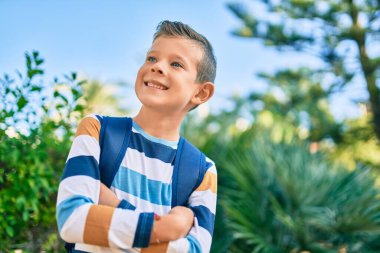 Kafkasyalı bir öğrenci parkta mutlu bir şekilde gülümsüyor..