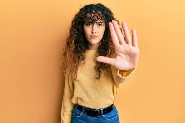 Günlük kıyafetler giyen genç İspanyol kız avucunun içi gibi şarkı söylemeyi kesiyor. Yüzünde olumsuz ve ciddi bir jest olan uyarı ifadesi. 