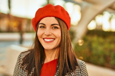 Genç İspanyol kadın gülümseyerek şehirde mutlu mesut dikiliyor..