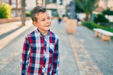 Sevimli beyaz çocuk, şehirde mutlu mesut dikiliyor..