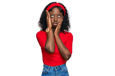 Güzel Afrikalı genç bir kadın günlük kıyafetler giyiyor. Yorgun eller, yüzünü kapatıyor. Depresyon ve üzüntü yaşıyor. 