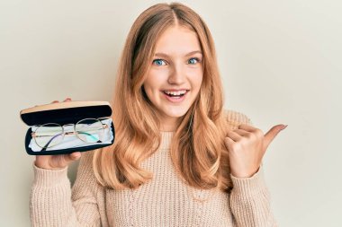 Güzel, beyaz, gözlüklü, ağzı açık, gülümseyen bir kız. 