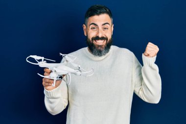 İHA 'yı tutan genç İspanyol adam gururla haykırıyor, zaferi ve başarıyı kutluyor. 