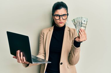 İş tarzı dizüstü bilgisayar giyen İspanyol genç bir kadın ve 50 avro şüpheci ve gergin, sorun yüzünden surat asıyor. negatif kişi. 
