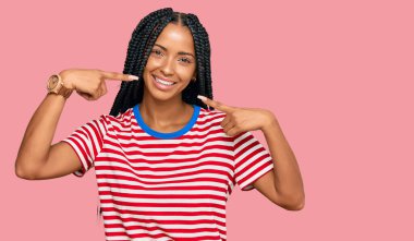 Güzel İspanyol kadın gündelik kıyafetler giyip neşeli gülüyor ve parmaklarıyla ve ağzıyla işaret ediyor. diş sağlığı kavramı. 