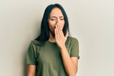Gündelik tişört giyen genç İspanyol kız ağzıyla ağzını kapatmaktan sıkılmış. Huzursuz ve uykulu.. 