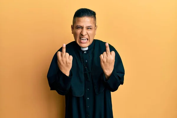 Young Latin Priest Man Standing Yellow Background Showing Middle Finger — Stock Fotó