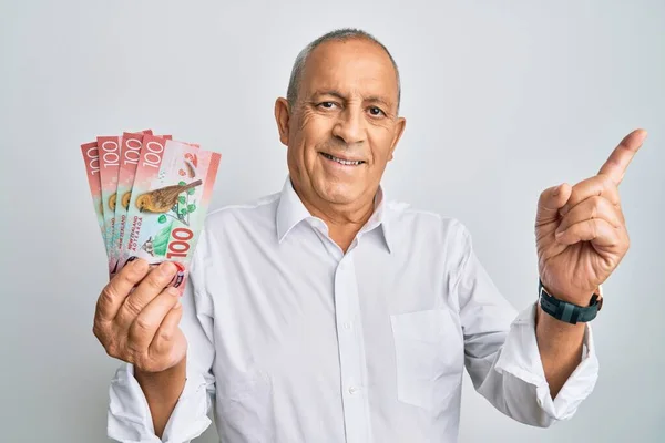 Handsome Senior Man Holding 100 New Zealand Dollars Banknote Smiling — Stock Photo, Image