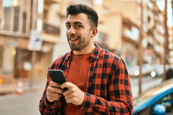 Ung Latinamerikansk Man Ler Glad Med Smartphone Stan — Stockfoto