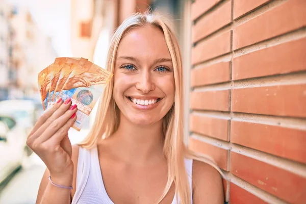 Młoda Blondynka Uśmiechnięta Szczęśliwa Trzymając Szwajcarskie Banknoty Frankowe Mieście — Zdjęcie stockowe