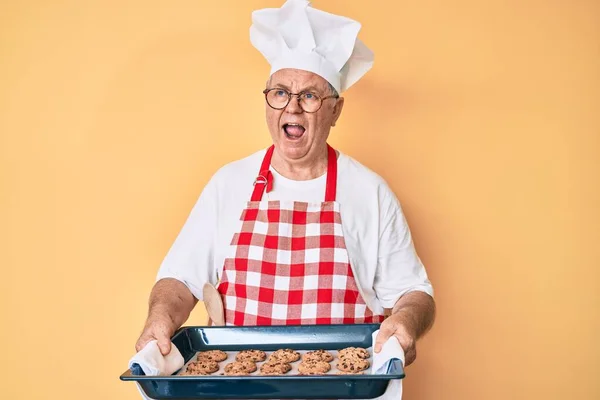 Älterer Grauhaariger Mann Bäckeruniform Mit Selbstgebackenen Keksen Wütend Und Verrückt — Stockfoto