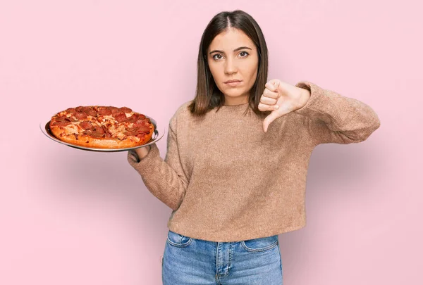 Jovem Mulher Bonita Segurando Pizza Italiana Com Rosto Irritado Sinal — Fotografia de Stock