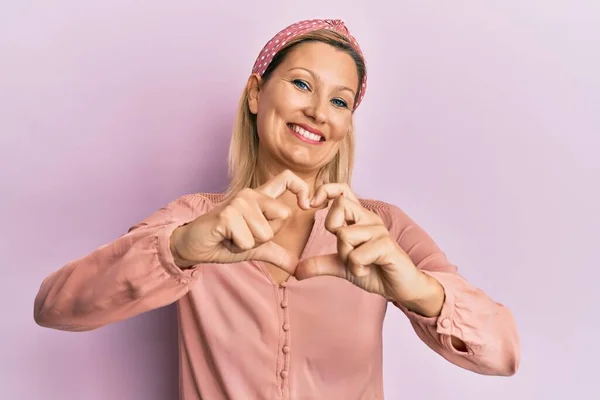 Orta Yaşlı Beyaz Kadın Sıradan Kıyafetler Giyip Aşıkken Gülümsüyor Elleriyle — Stok fotoğraf