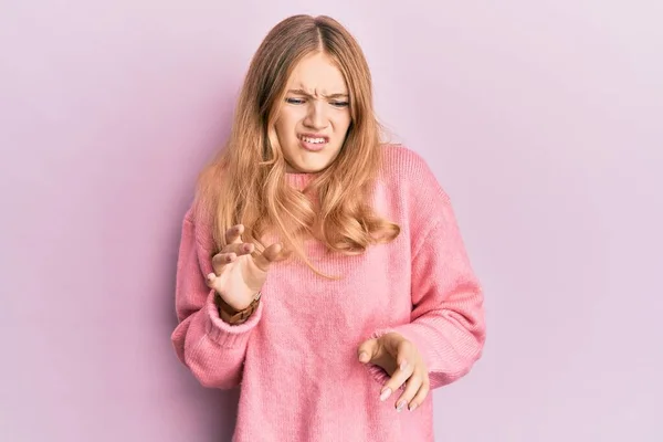 Beautiful young caucasian girl wearing casual clothes disgusted expression, displeased and fearful doing disgust face because aversion reaction.