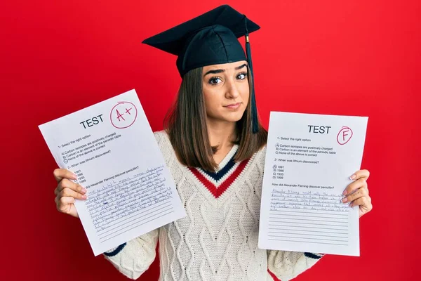 Young Brunette Girl Wearing Graduation Cap Showing Exams Clueless Confused — Fotografia de Stock