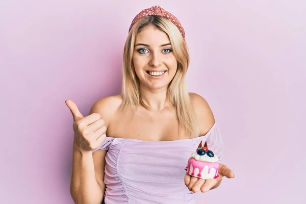 Młoda Kaukaska Kobieta Trzyma Ciasto Słodycze Uśmiechnięty Szczęśliwy Pozytywny Kciuk — Zdjęcie stockowe