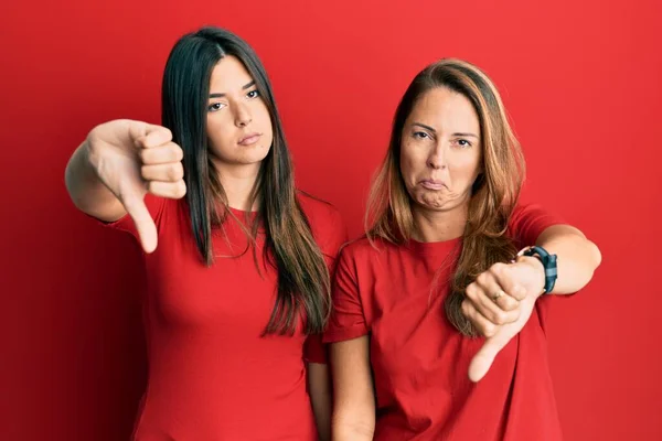 Família Hispânica Mãe Filha Vestindo Roupas Casuais Sobre Fundo Vermelho — Fotografia de Stock