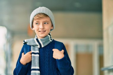 Sevimli sarışın öğrenci okulda mutlu bir şekilde gülümsüyor..