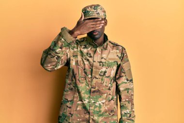 Genç Afro-Amerikan askeri üniforma giyen, gözlerini kapayan, ciddi ve üzgün görünen bir adam. Görme, saklama ve reddetme konsepti 