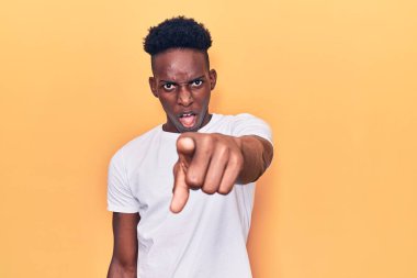 Genç, Afro-Amerikan bir adam, gündelik giysiler içinde kameraya kızgın ve hayal kırıklığına uğramış bir şekilde bakıyor. 