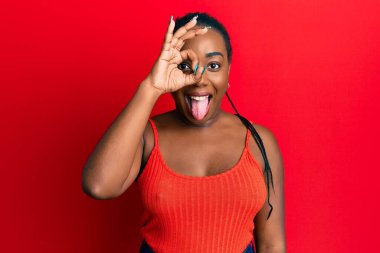 Genç Afro-Amerikalı kadın iyi. Gözlerine işaret koy. Dilini dışarı çıkart. Komik bir ifadeyle.. 