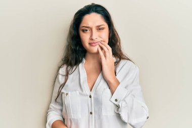 Güzel bir ortadoğulu kadın diş ağrısı ya da diş hastalığından dolayı dişleriyle dudaklarına dokunarak acı dolu bir ifade sergiliyor. dişçi 