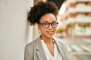 Genç Afrikalı Amerikalı iş kadını şehirde mutlu bir şekilde dikiliyor..