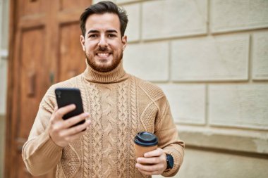 Kafkasyalı genç adam akıllı telefon kullanıyor. Şehirde kahve içiyor..