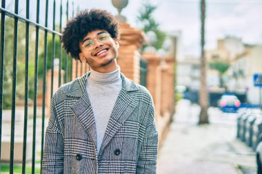 Genç Afrikalı Amerikalı iş adamı şehirde mutlu mesut dikiliyor..