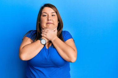 Güzel esmer, iri yarı, sıradan mavi tişört giyen bir kadın bağırıyor ve boğuluyor çünkü acı verici bir boğulma. Sağlık problemi. Boğulma ve intihar konsepti. 