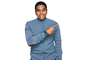 Genç, yakışıklı, günlük kazak giyen, endişeli, endişeli ve şaşırmış bir ifade takınan, endişeli ve endişeli bir adam. 