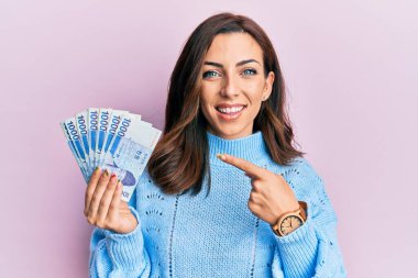 1000 Güney Koreli 'yi tutan genç esmer kadın para kazandı. Gülümseyerek mutlu bir şekilde el ve parmak salladı. 