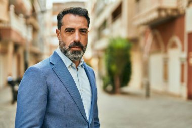 Şehirde duran rahat yüzlü orta yaşlı iş adamı..