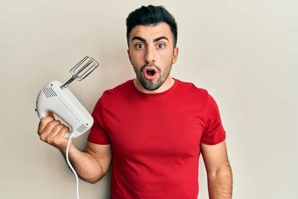 Young Hispanic Man Holding Food Processor Mixer Machine Scared Amazed — Stock Photo, Image