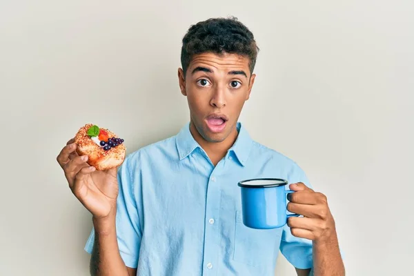 Jovem Afro Americano Bonito Bebendo Café Comendo Pastelaria Face Choque — Fotografia de Stock